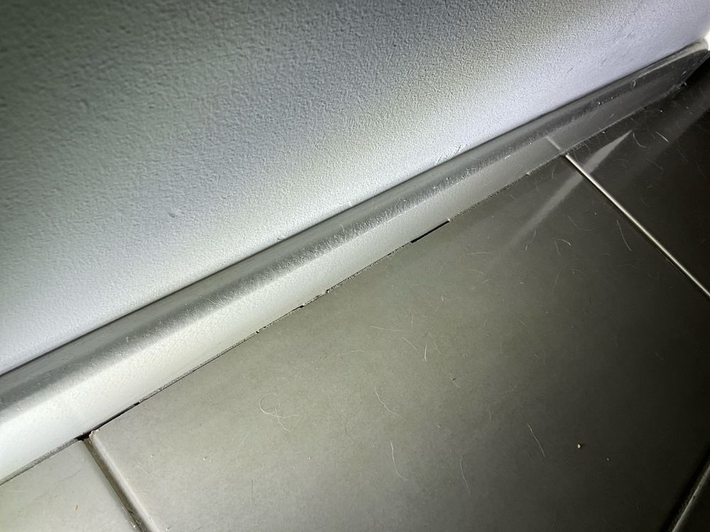 Tiles grouted hard against the wall where a flexible sealant was needed, found during a defect investigation inspection in Werribee