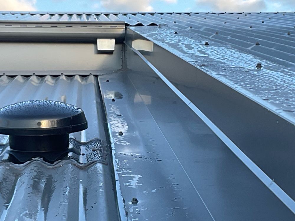 Gutter outlet discharging over roof flashing with no spreader fitted, Werribee