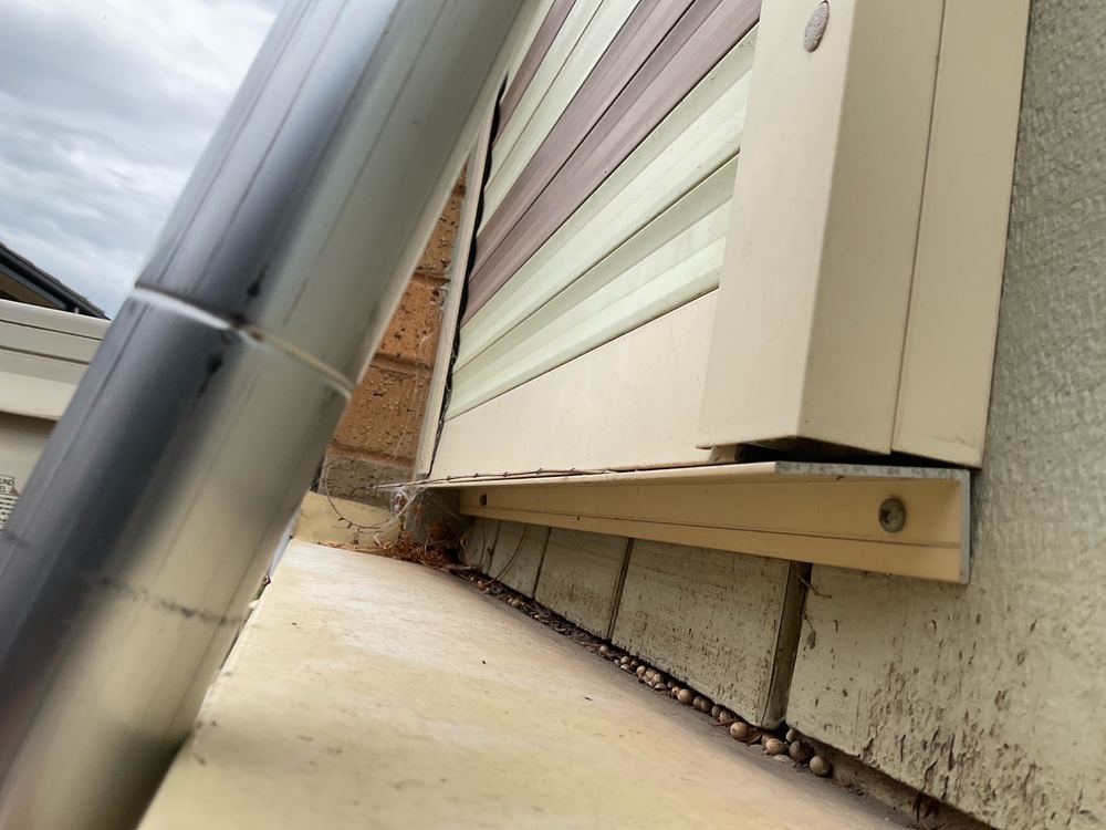 Parapet flashing sloping toward the building, so water runs inward, found during a pre-purchase inspection in Sunshine North